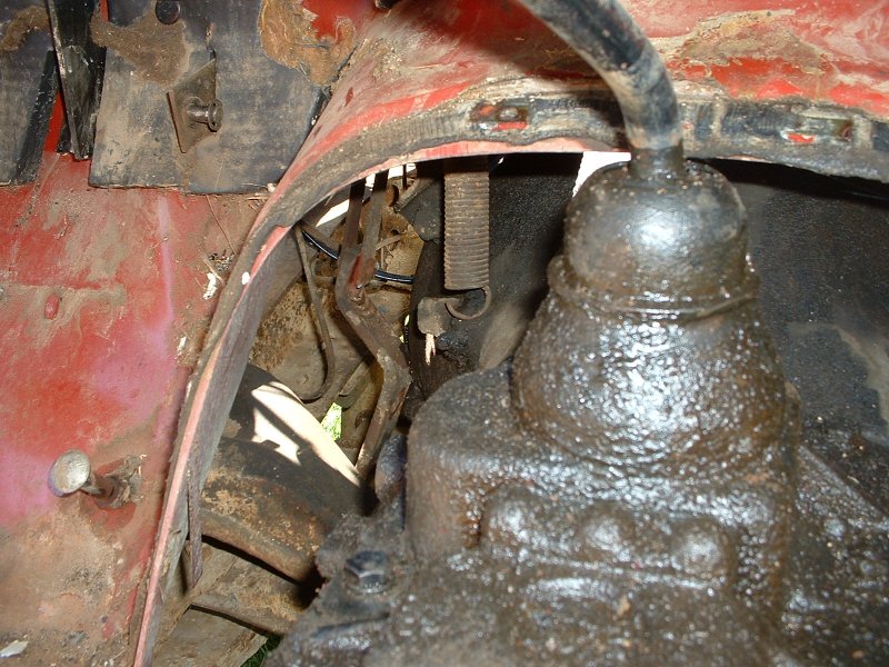 View of the transmission with the floor cover off. You can see the shaft that sheared off on the left side, just below the sprint that is hanging down in the picture
